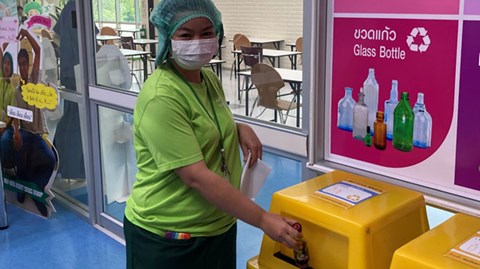 Thaise medewerker gooit afval in een recyclingstation