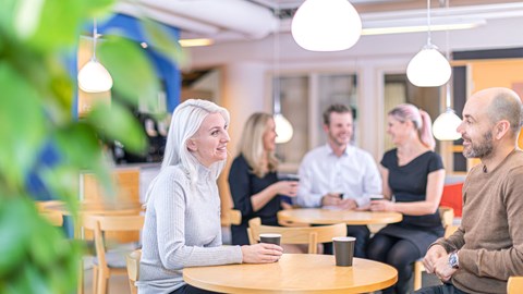 medewerkers die koffie drinken en lachen